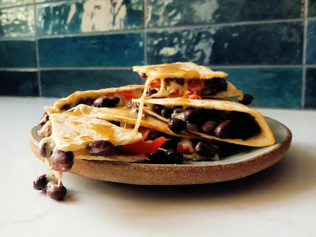 Stack of chorizo black bean quesadillas dripping with cheese