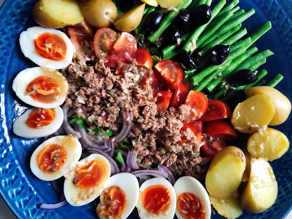 Nicoise salad with hard boiled eggs, tuna, potatoes, green beans, tomatoes