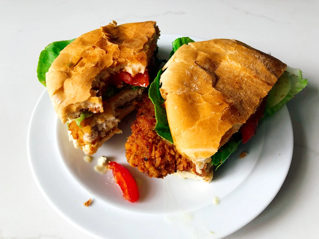 Pork schnitzel sandwich on bun with two bites taken out