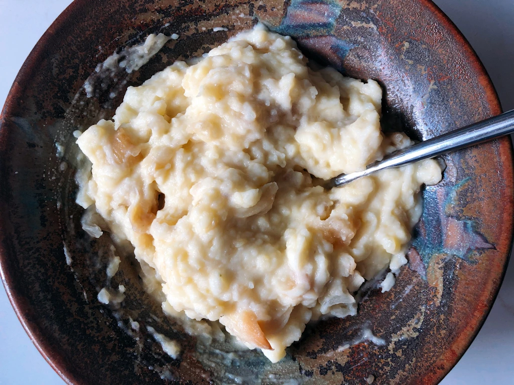 Roasted Garlic Onion Mash in a brown bowl with a silver spoon