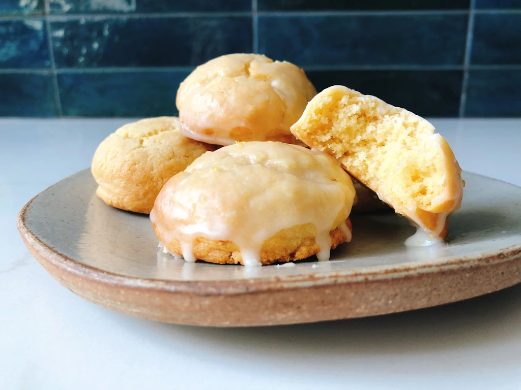 Plate of four lemon cookies with lemon glaze.