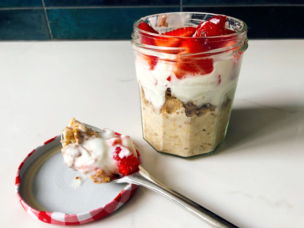 Strawberries and Cream Overnight Oats in a jar with a spoon