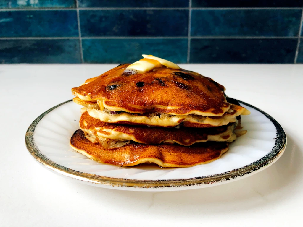 Stack of American diner style buttermilk pancakes with butter on top