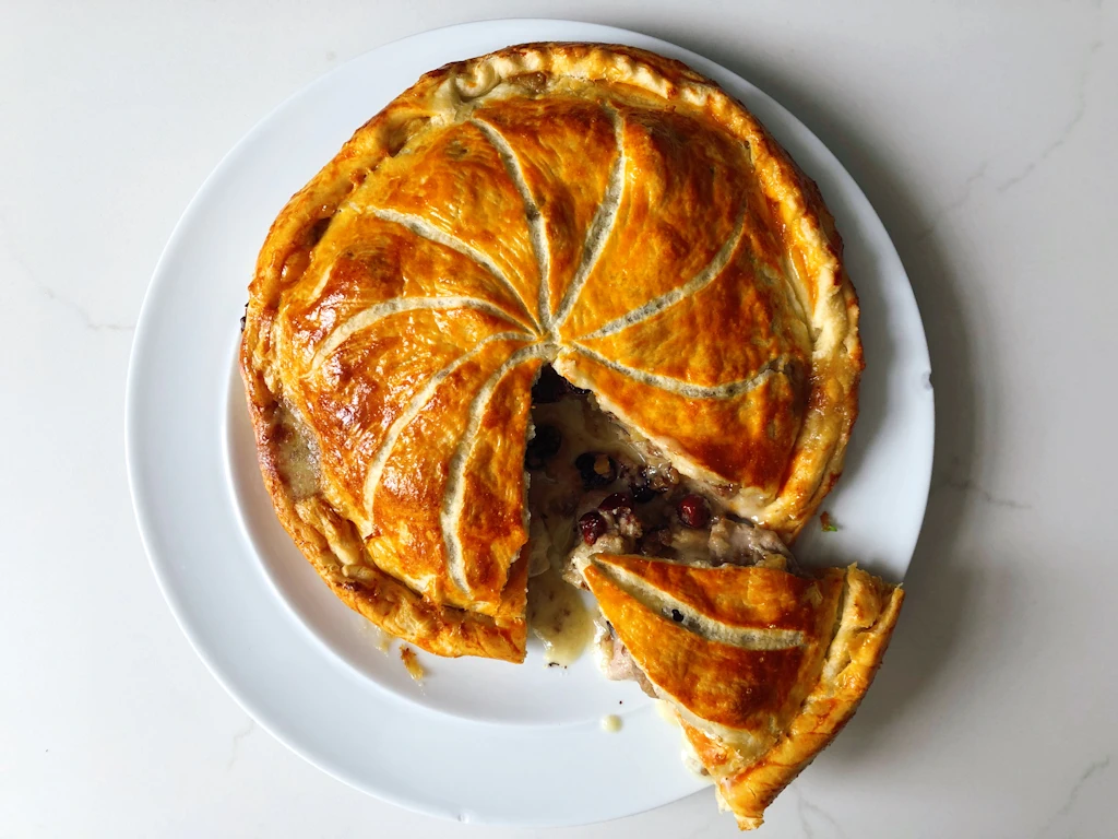 Round plate with a chicken brie pithivier with one slice removed