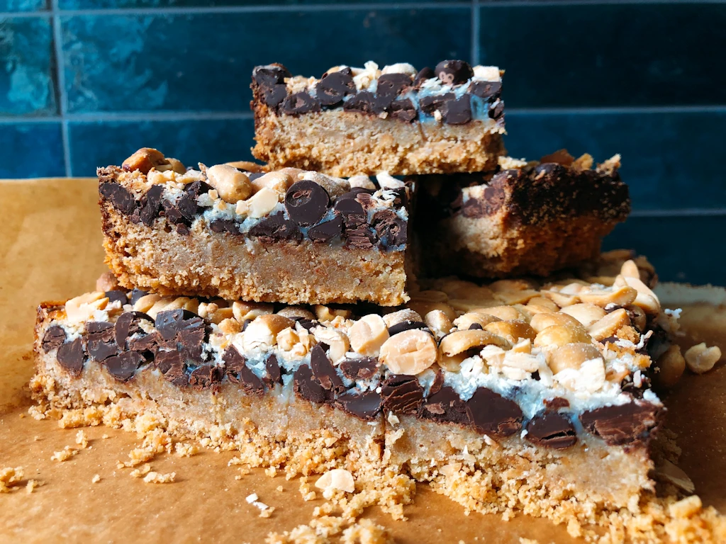 Plate full of magic dessert bars with blue tile background