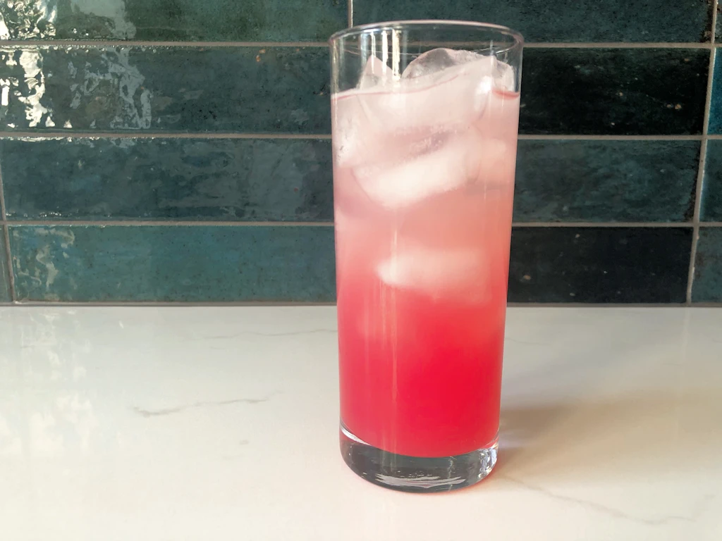 Tall glass with ice and non alcoholic rhubarb cooler