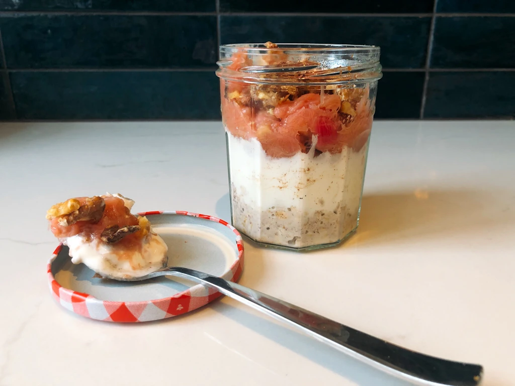 Jar of rhubarb roast walnut overnight oats with spoon